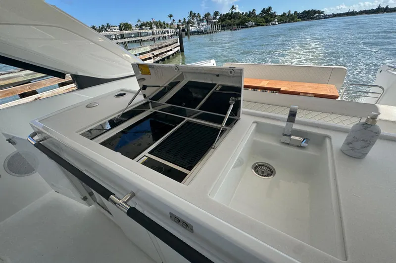  Yacht Photos Pics Outdoor kitchen on 2024 Jeanneau DB43 yacht with sink and grill, overlooking water.