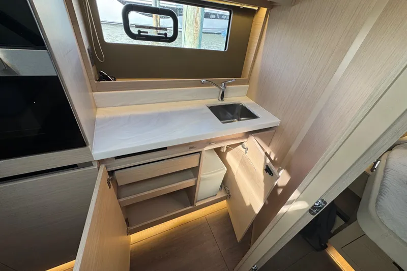  Yacht Photos Pics 2024 Jeanneau DB43 yacht interior kitchen with sink, cabinets, and window view.