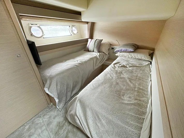  Yacht Photos Pics Twin cabin interior of 2014 Ferretti Yachts 690 with porthole windows and cozy bedding.