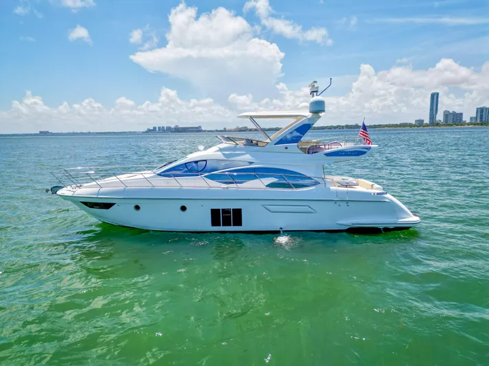  Yacht Photos Pics Luxurious 2015 Azimut 54 Fly yacht cruising on clear blue waters under a sunny sky.