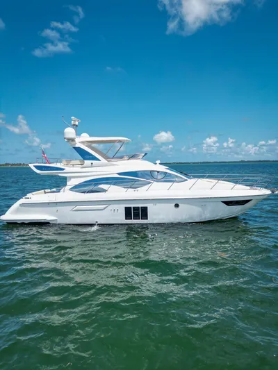  Yacht Photos Pics 2015 Azimut 54 Fly yacht cruising on open water under clear blue skies.
