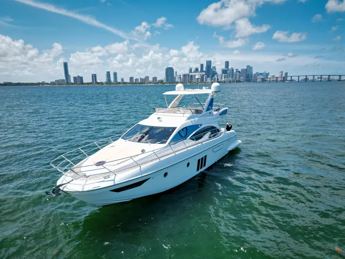  Yacht Photos Pics Luxury 2015 Azimut 54 Fly yacht cruising near city skyline under blue skies.