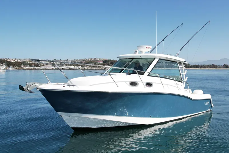 Strike Zone Yacht Photos Pics 2018 Boston Whaler 315 Conquest boat on calm water, featuring a sleek blue and white design.