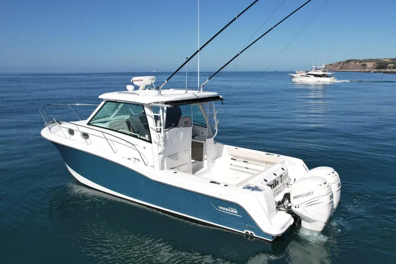 Strike Zone Yacht Photos Pics 2018 Boston Whaler 315 Conquest boat on calm ocean waters.
