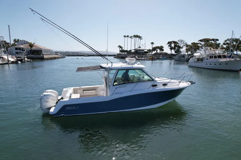 Strike Zone Yacht Photos Pics 2018 Boston Whaler 315 Conquest boat on calm water in a marina setting.