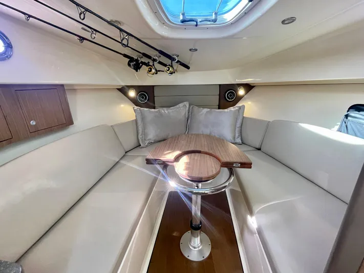 Strike Zone Yacht Photos Pics 2018 Boston Whaler 315 Conquest cabin interior with seating and table.