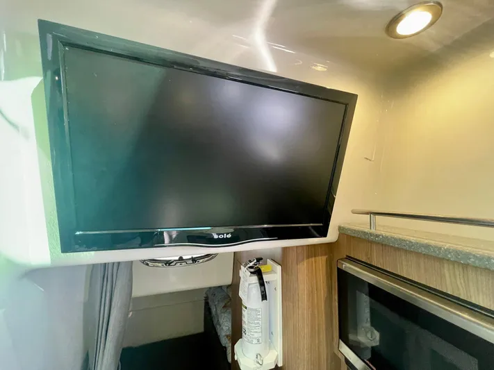 Strike Zone Yacht Photos Pics 2018 Boston Whaler 315 Conquest cabin interior with mounted TV and modern amenities.