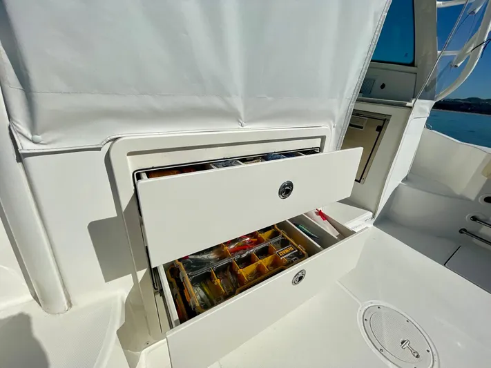 Strike Zone Yacht Photos Pics 2018 Boston Whaler 315 Conquest boat with open storage drawer, showcasing organized compartments.