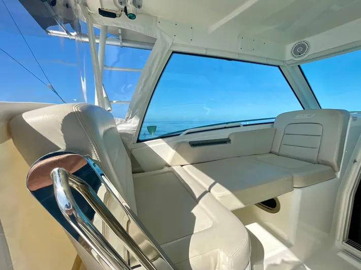 Strike Zone Yacht Photos Pics Interior view of 2018 Boston Whaler 315 Conquest boat with white seating and ocean backdrop.