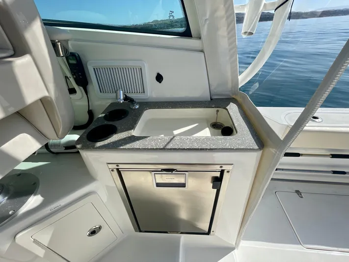 Strike Zone Yacht Photos Pics 2018 Boston Whaler 315 Conquest boat interior with sink and storage.