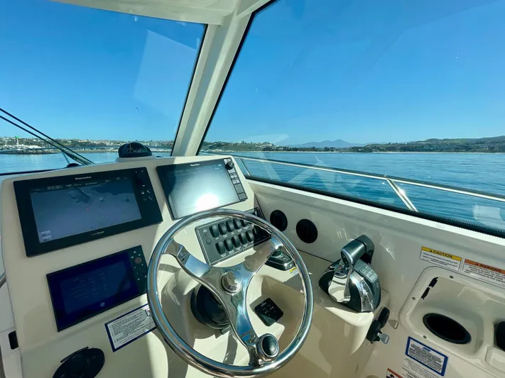 Strike Zone Yacht Photos Pics Helm of 2018 Boston Whaler 315 Conquest with navigation screens and steering wheel.
