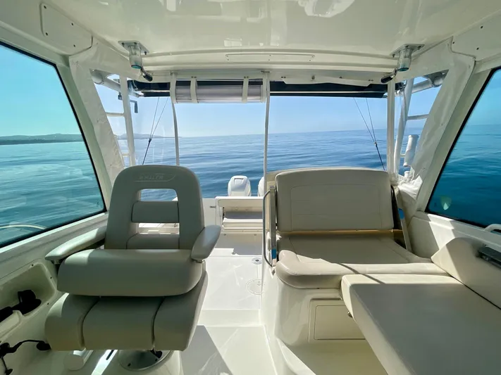 Strike Zone Yacht Photos Pics 2018 Boston Whaler 315 Conquest interior with seating, ocean view, and fishing rods.