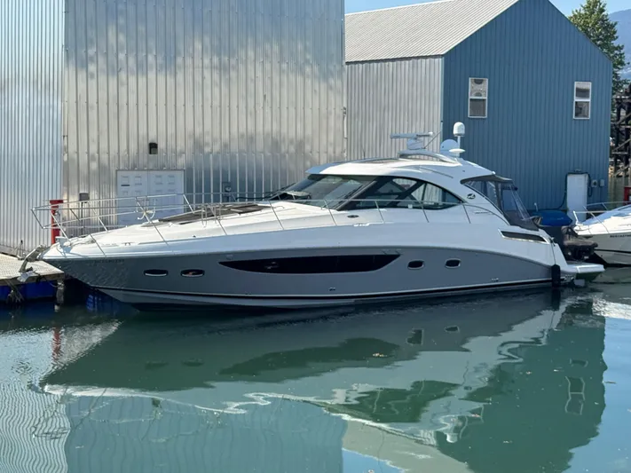  Yacht Photos Pics 2013 Sea Ray 470 Sundancer yacht docked beside metal buildings.