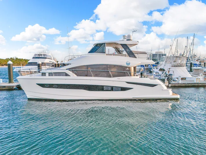  Yacht Photos Pics 2023 Aquila 54 Yacht docked in a marina under a bright blue sky.