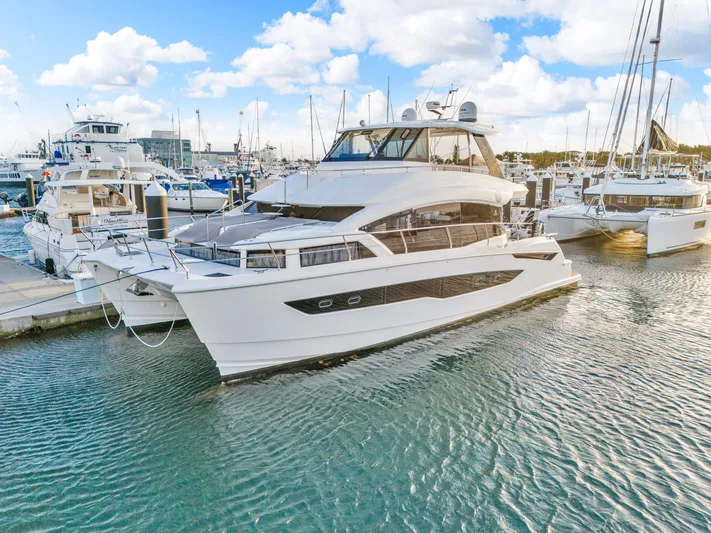  Yacht Photos Pics 2023 Aquila 54 Yacht docked at marina under blue sky.