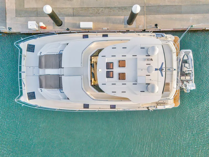  Yacht Photos Pics Aerial view of 2023 Aquila 54 Yacht docked in turquoise water.