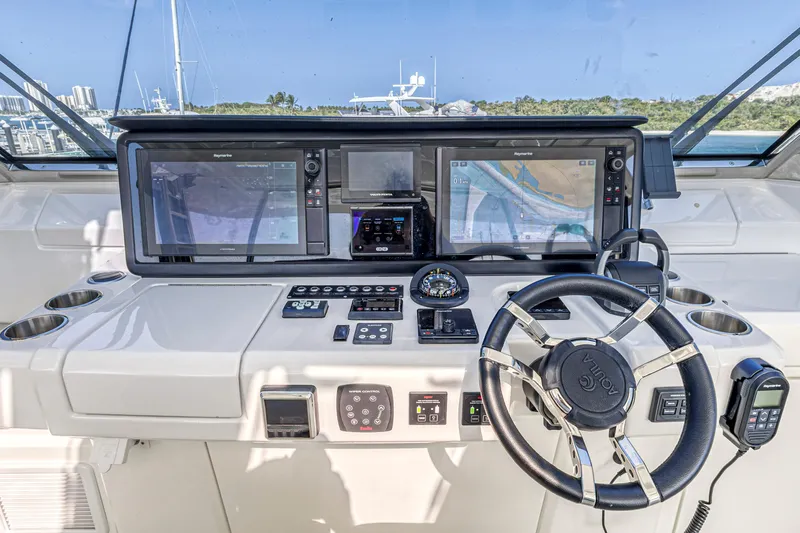  Yacht Photos Pics Control panel of 2023 Aquila 54 Yacht with navigation screens and steering wheel.