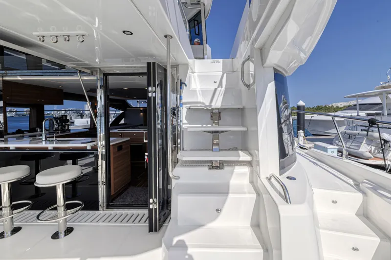  Yacht Photos Pics Aquila 54 Yacht 2023 interior with modern design, featuring bar stools and sleek staircase.