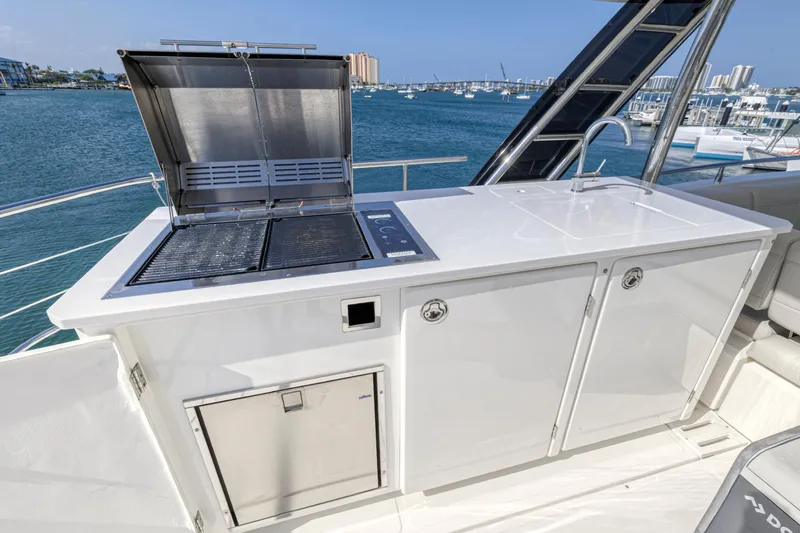  Yacht Photos Pics Outdoor kitchen on 2023 Aquila 54 Yacht with grill and storage, overlooking marina.