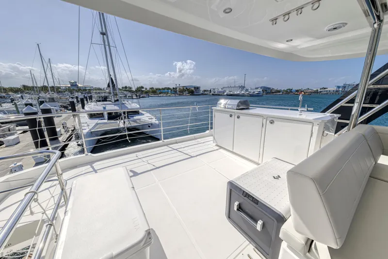  Yacht Photos Pics Aquila 54 Yacht 2023 deck with marina view, featuring seating and storage.
