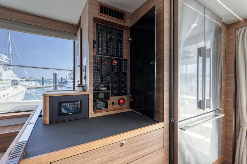  Yacht Photos Pics Control panel inside 2023 Aquila 54 Yacht, featuring modern wood finish and marina view.