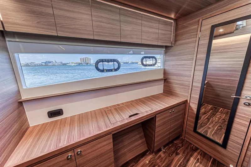  Yacht Photos Pics Interior of 2023 Aquila 54 Yacht with wooden cabinetry and ocean view window.