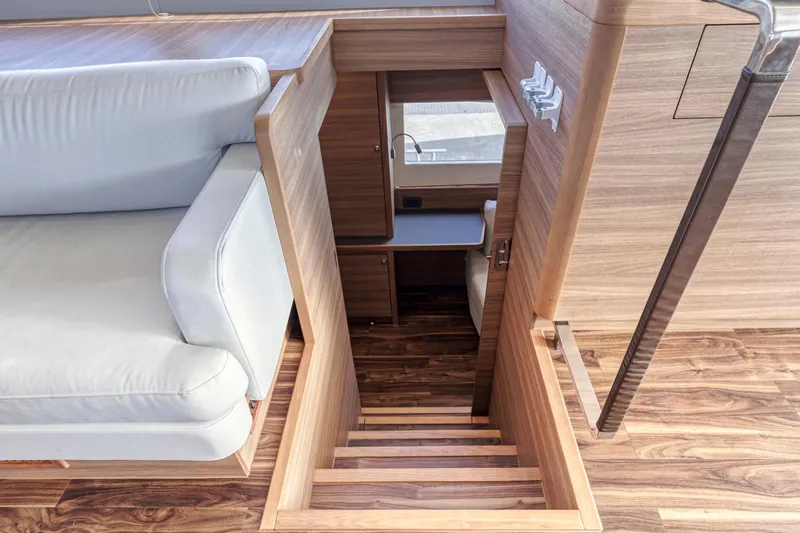  Yacht Photos Pics Interior of 2023 Aquila 54 Yacht with wooden stairs and white seating.