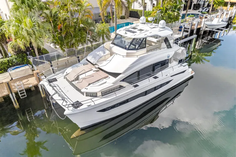  Yacht Photos Pics 2023 Aquila 54 Yacht docked in a serene marina setting.