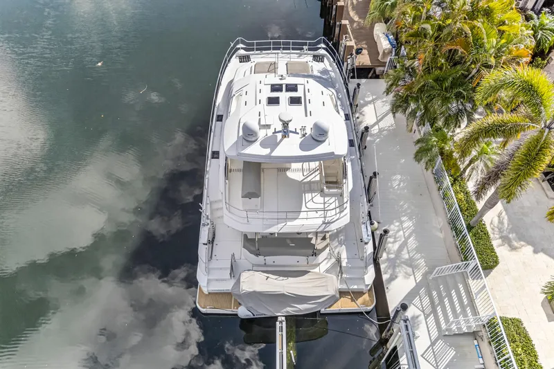  Yacht Photos Pics Aerial view of 2023 Aquila 54 Yacht docked beside lush palm trees.
