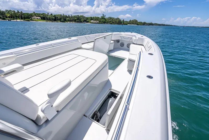 Clean Trade-ins Accepted - Bring Offers Yacht Photos Pics 2021 Contender 44 CB boat on clear blue water, featuring spacious seating and sleek design.