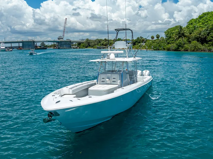 Clean Trade-ins Accepted - Bring Offers Yacht Photos Pics 2021 Contender 44 CB boat on clear blue water near a bridge and lush greenery.