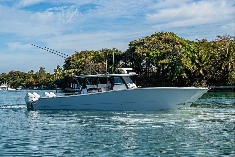  Yacht Photos Pics 2023 Freeman 47 boat cruising on a sunny day near lush greenery.