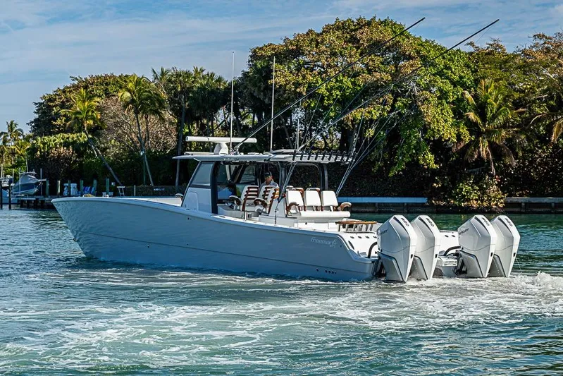  Yacht Photos Pics 2023 Freeman 47 boat cruising on water with lush greenery in the background.
