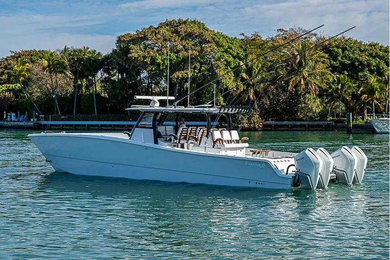  Yacht Photos Pics 2023 Freeman 47 boat with multiple engines on calm water, surrounded by lush greenery.