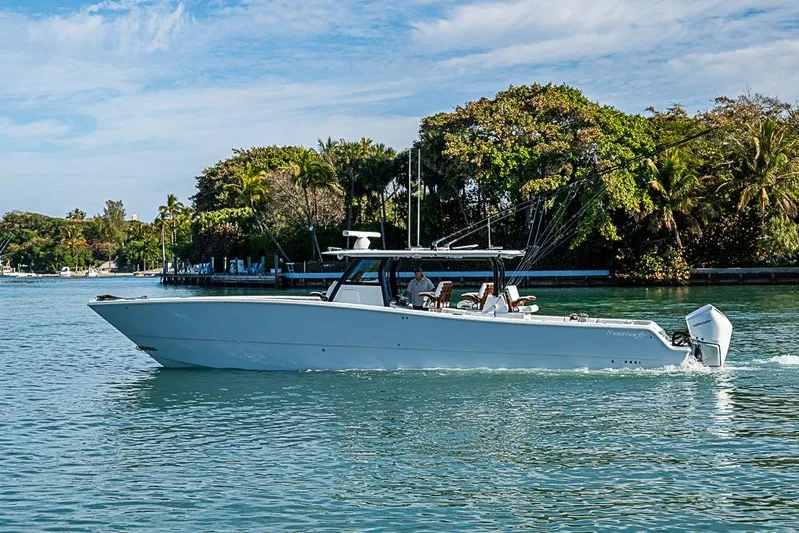  Yacht Photos Pics 2023 Freeman 47 boat cruising on a serene waterway with lush greenery.