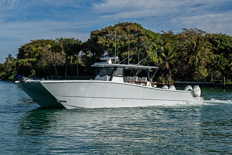  Yacht Photos Pics 2023 Freeman 47 boat cruising on a scenic waterway with lush greenery.