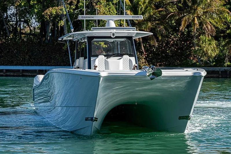  Yacht Photos Pics 2023 Freeman 47 boat cruising on a sunny day, surrounded by lush greenery.