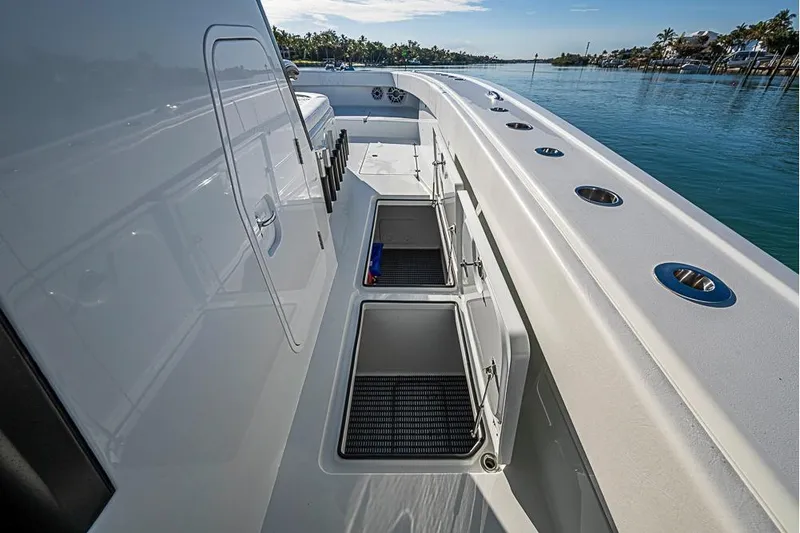  Yacht Photos Pics 2023 Freeman 47 boat deck with open storage compartments, docked by calm waters.