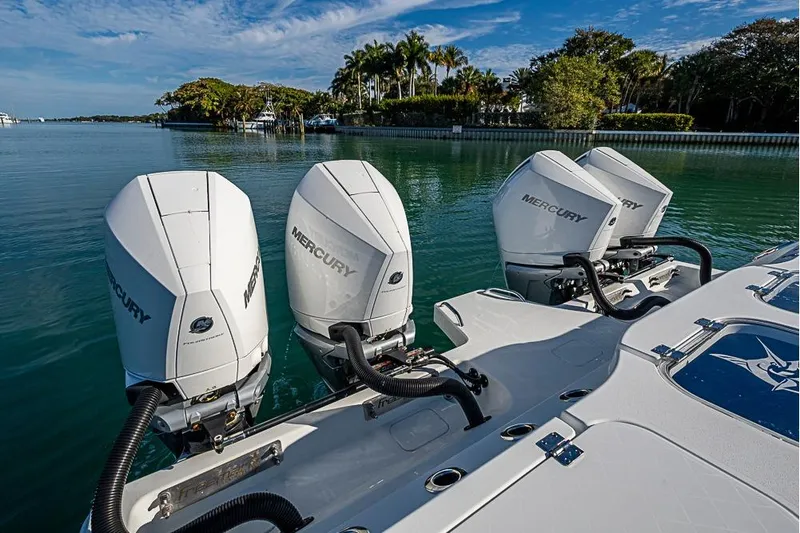  Yacht Photos Pics Four Mercury outboard engines on a 2023 Freeman 47 boat, docked by lush greenery.