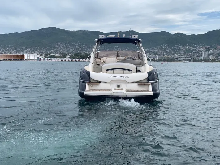  Yacht Photos Pics 1999 Sunseeker Superhawk 34 yacht on water with coastal city and mountains in background.