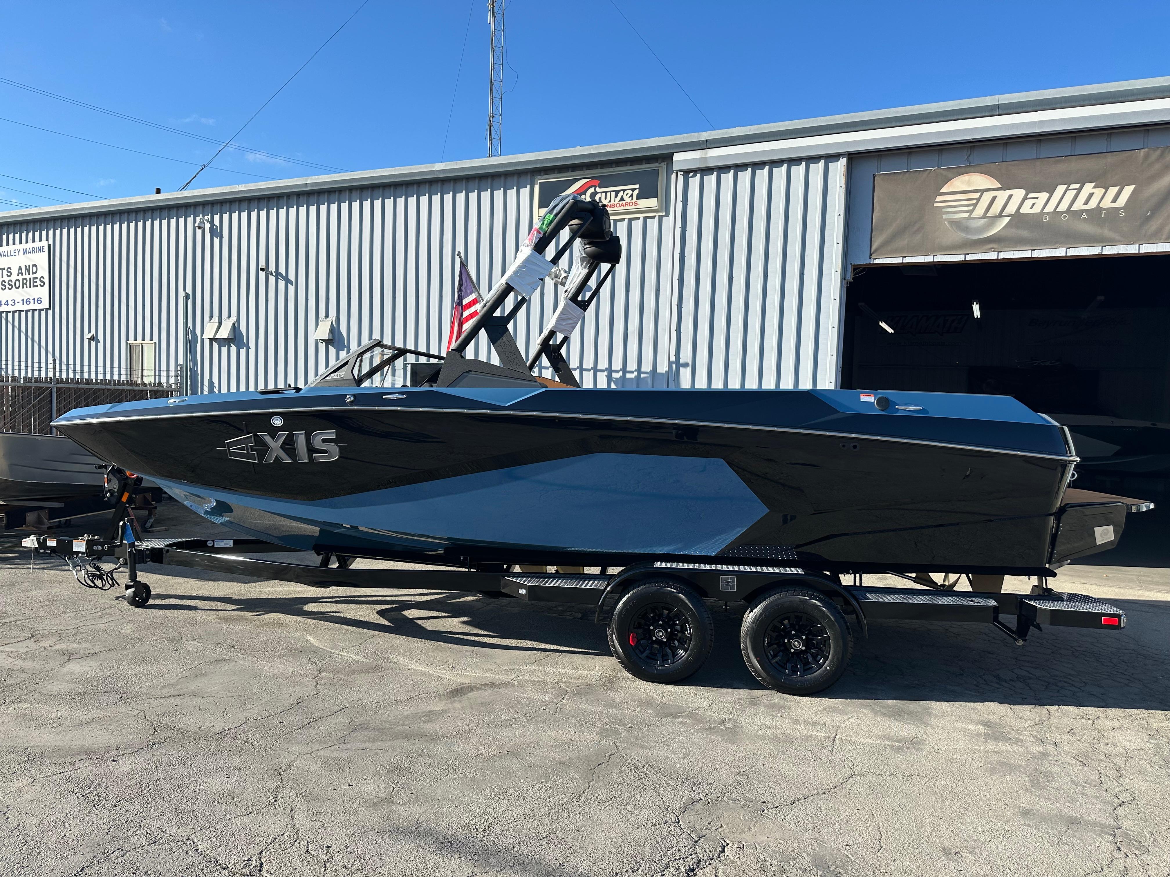2025 Axis A245 boat on trailer outside Malibu dealership, blue and black design.