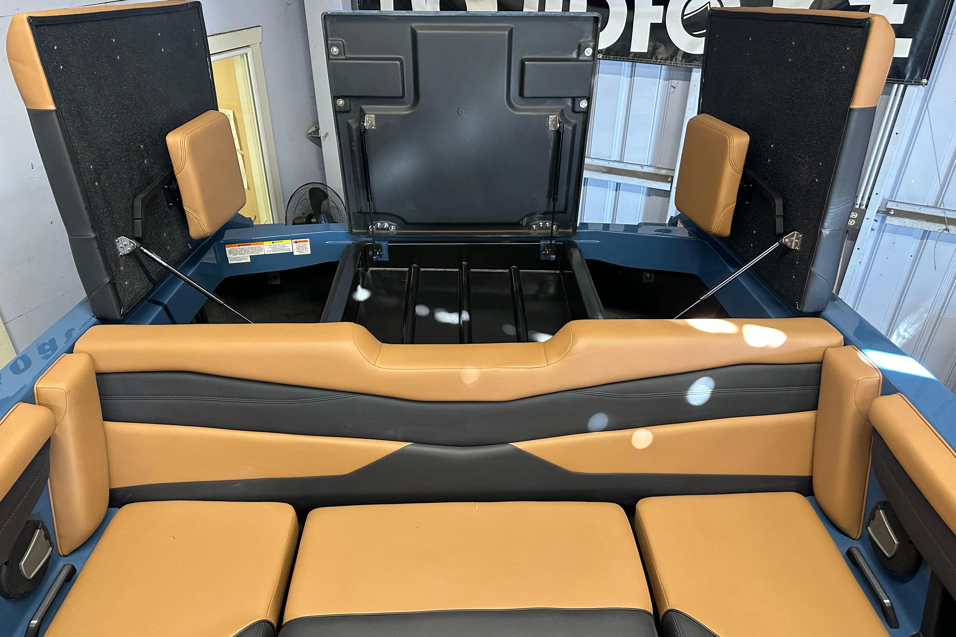 2025 Axis A245 boat interior with tan and black seating, open storage compartments.