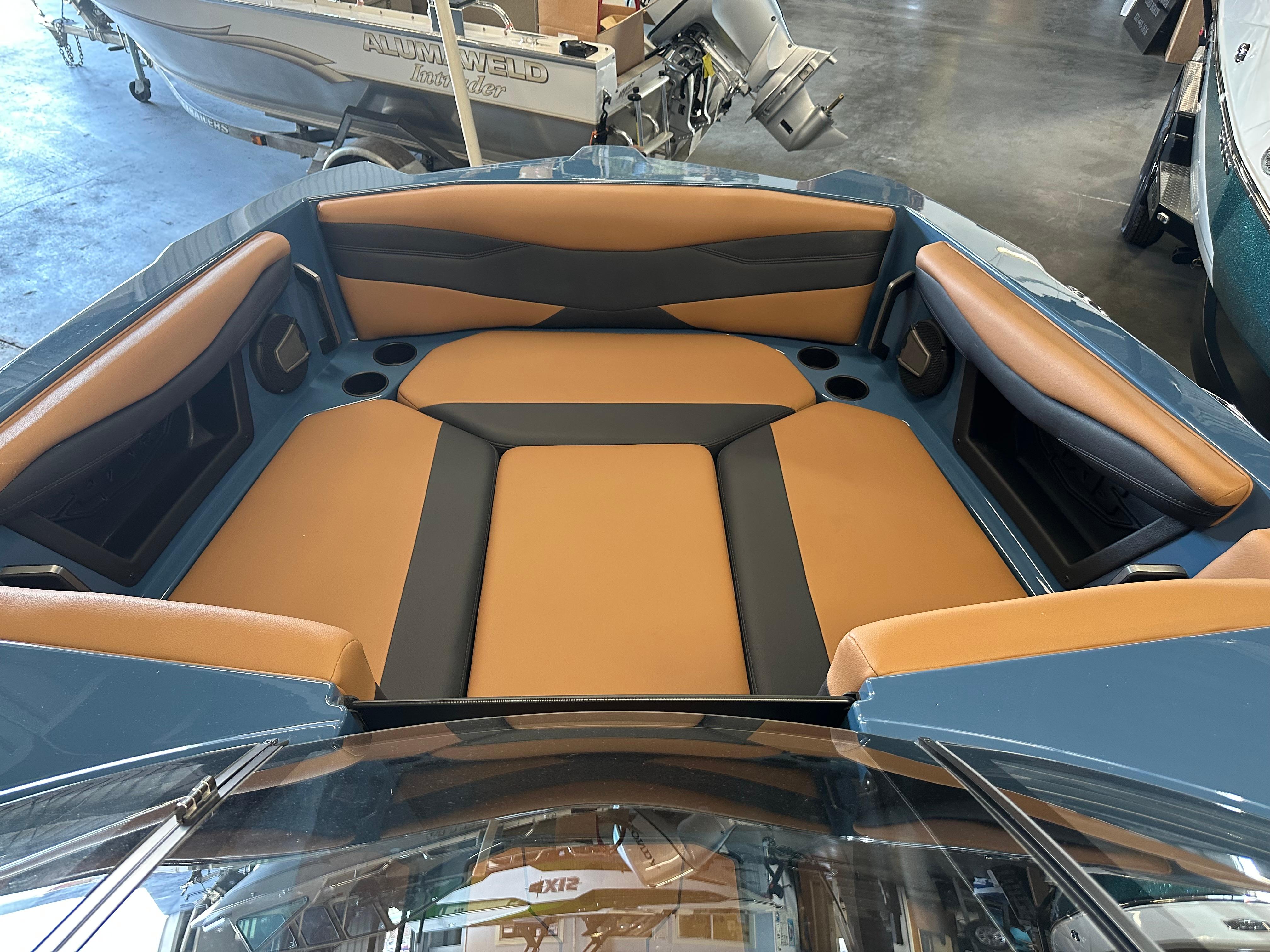 2025 Axis A245 boat interior with tan and black seating in a showroom.