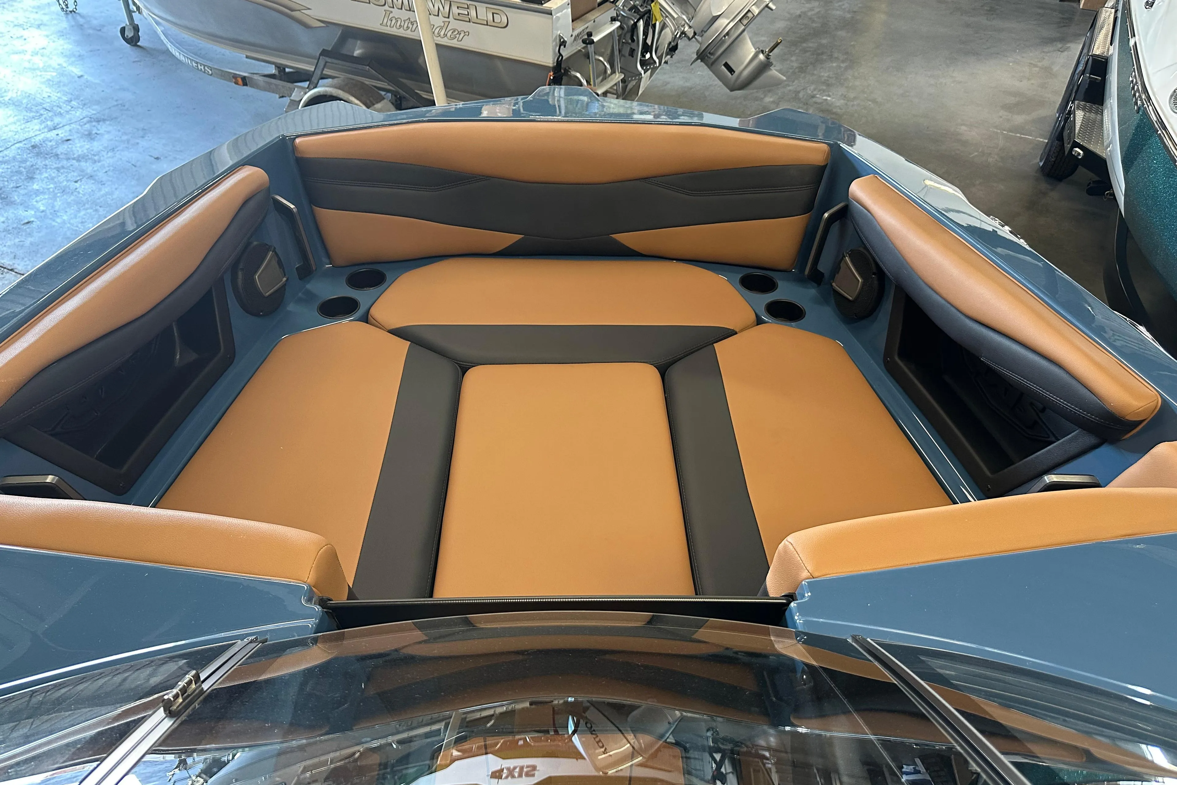 2025 Axis A245 boat interior with tan and black seating in a showroom.