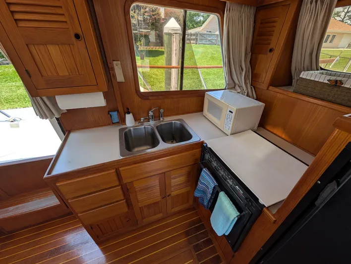 Monarch Yacht Photos Pics Wooden kitchen interior of 1997 Monk 36 boat with sink, stove, and microwave.