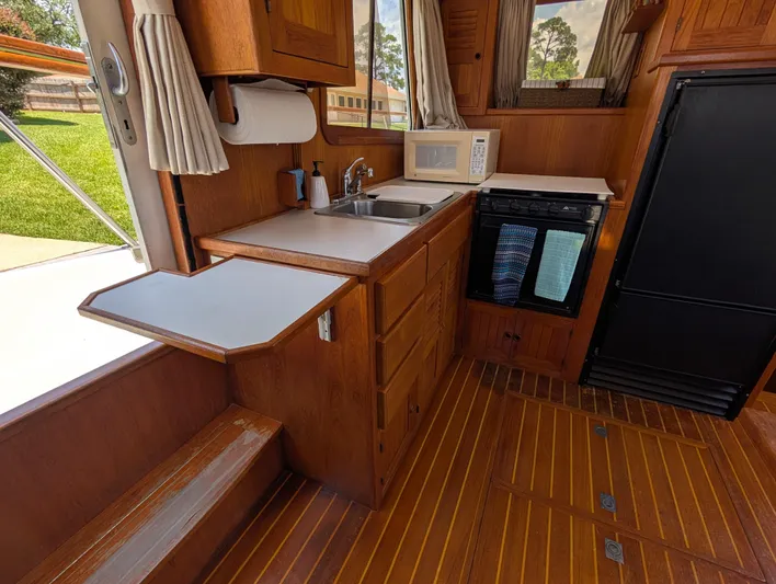 Monarch Yacht Photos Pics 1997 Monk 36 boat kitchen with wood cabinetry, sink, microwave, and compact appliances.