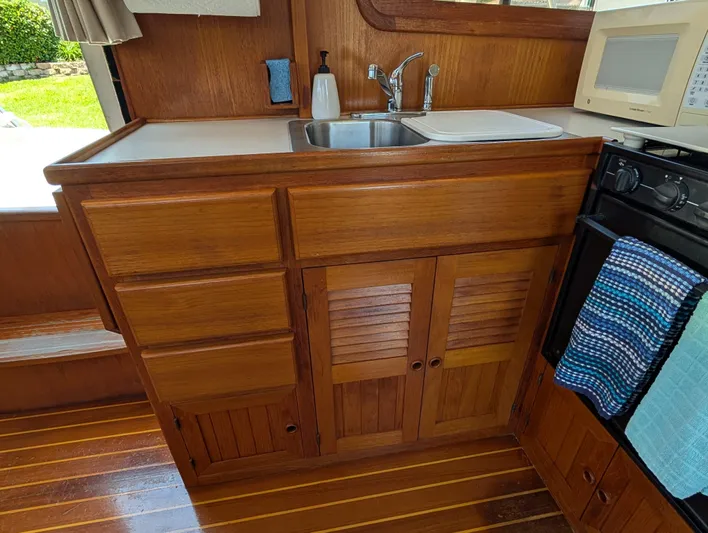 Monarch Yacht Photos Pics Wooden kitchen area in a 1997 Monk 36 boat, featuring a sink and stove.