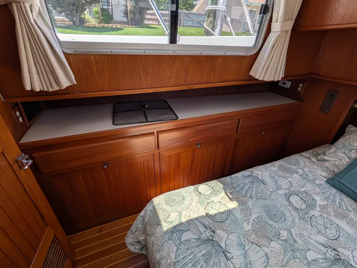 Monarch Yacht Photos Pics Cozy cabin interior of a 1997 Monk 36 boat with wooden cabinetry and patterned bedding.
