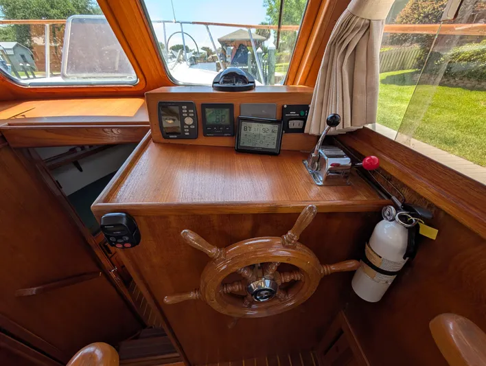 Monarch Yacht Photos Pics Wooden helm station of a 1997 Monk 36 boat with navigation instruments and fire extinguisher.