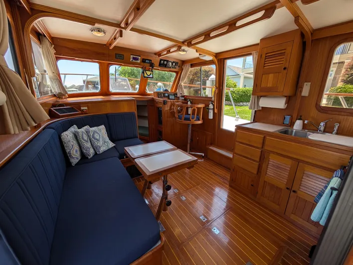 Monarch Yacht Photos Pics Interior of a 1997 Monk 36 boat with wooden furnishings and blue seating.